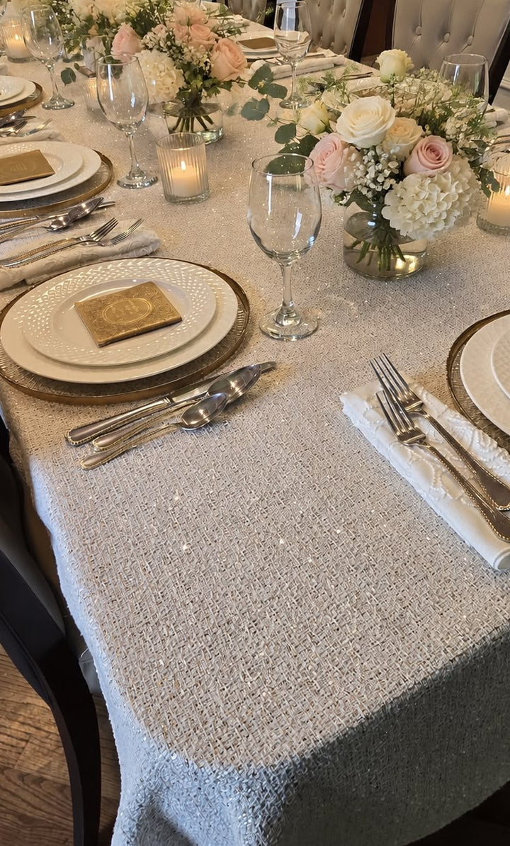 Vienna Boucle Tablecloth in off-white with gold sequin accents on a set dining table
